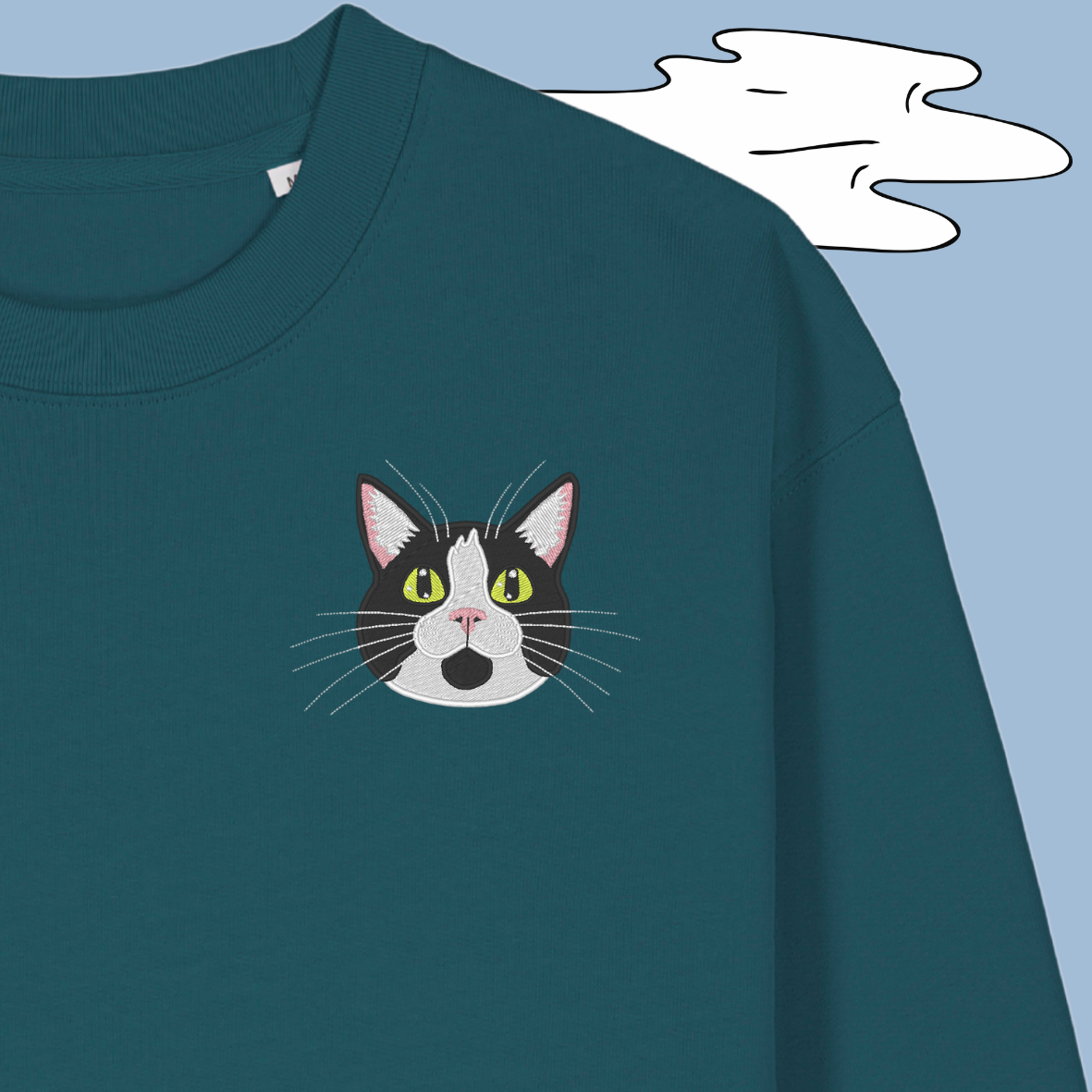 Teal sweatshirt with a cat face design on a blue background